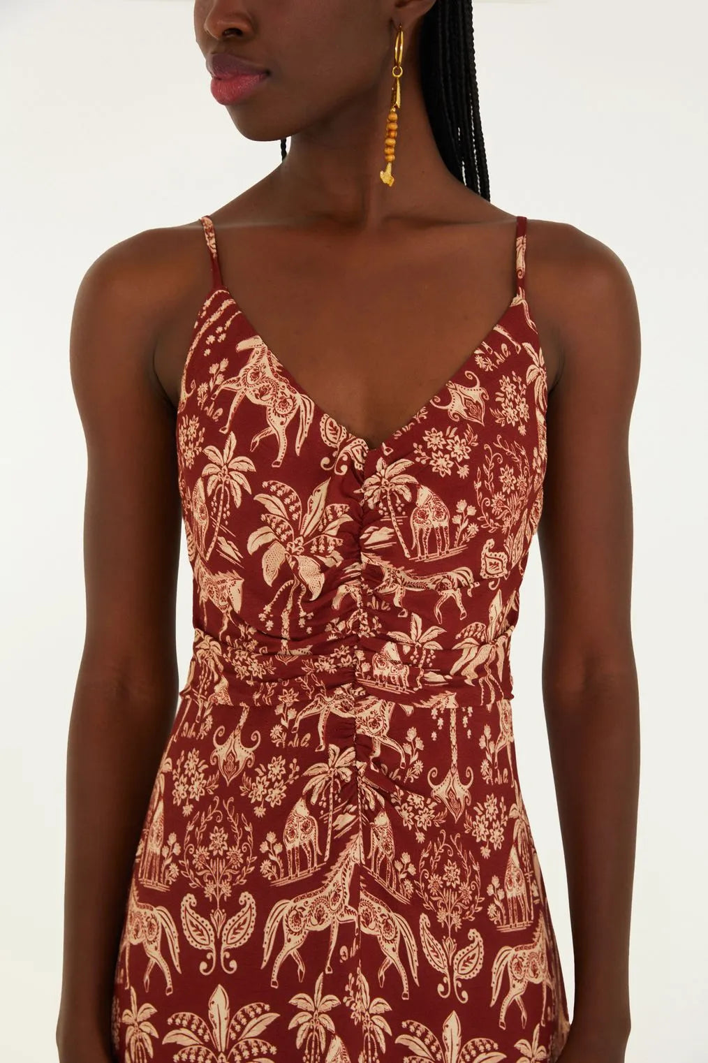 Mulher usando vestido estampado FARM Rio com fundo natural iluminado pelo sol, transmitindo leveza e autenticidade tropical.