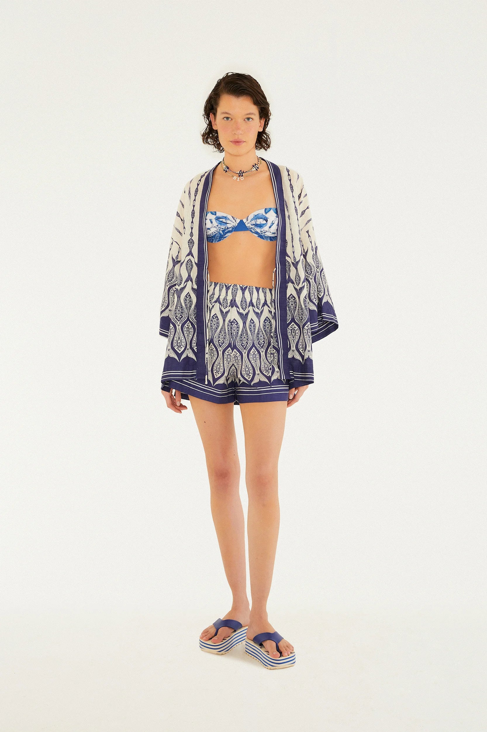 Vista ampla (zoom out) mostrando o look completo com o Kimono Estampado Peixe Correnteza FARM em ambiente natural e iluminado.