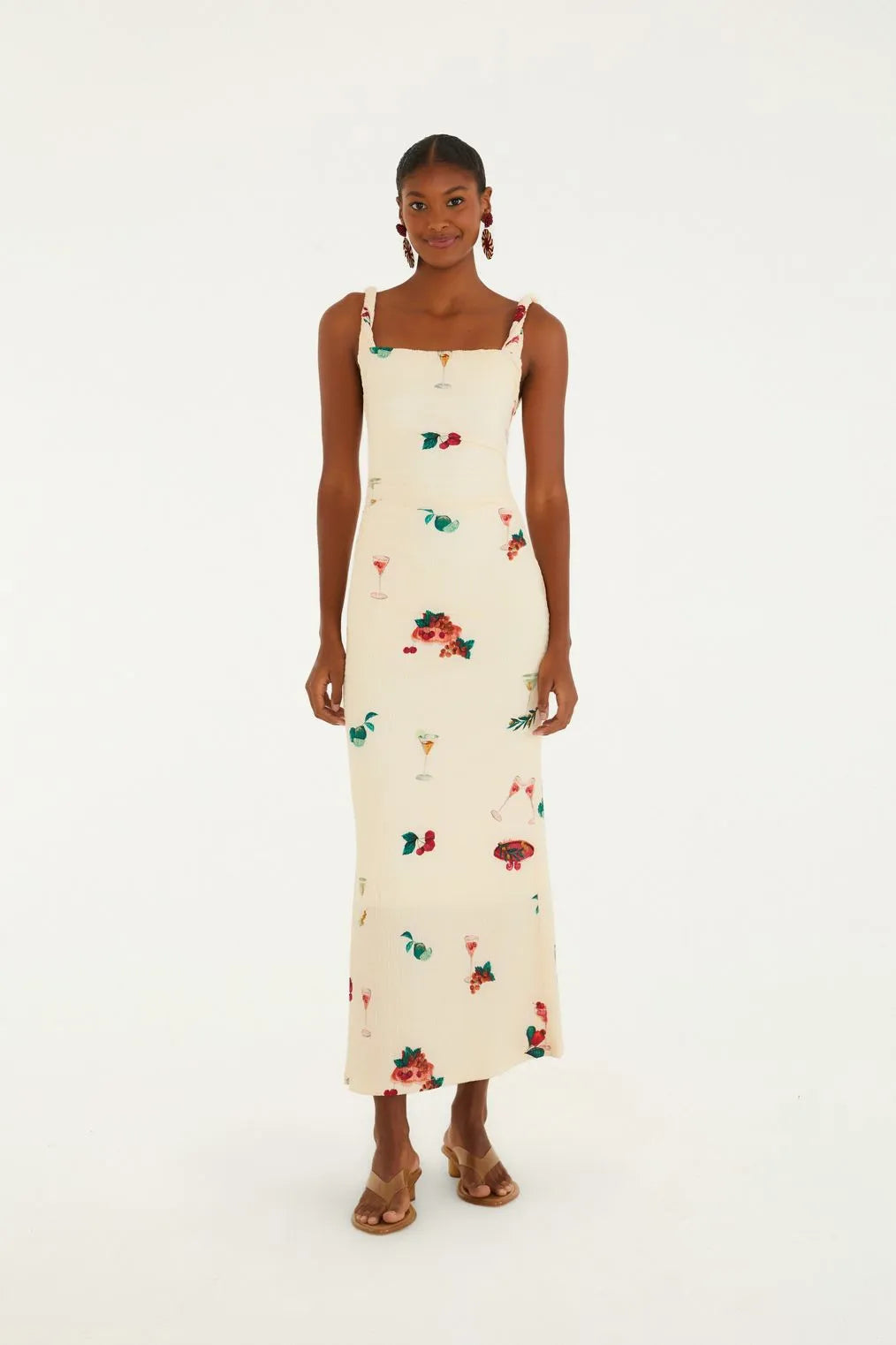 Modelo de frente usando o Vestido Alça Torcida Estampado Coquetel Tropical FARM, com decote quadrado e modelagem longa.