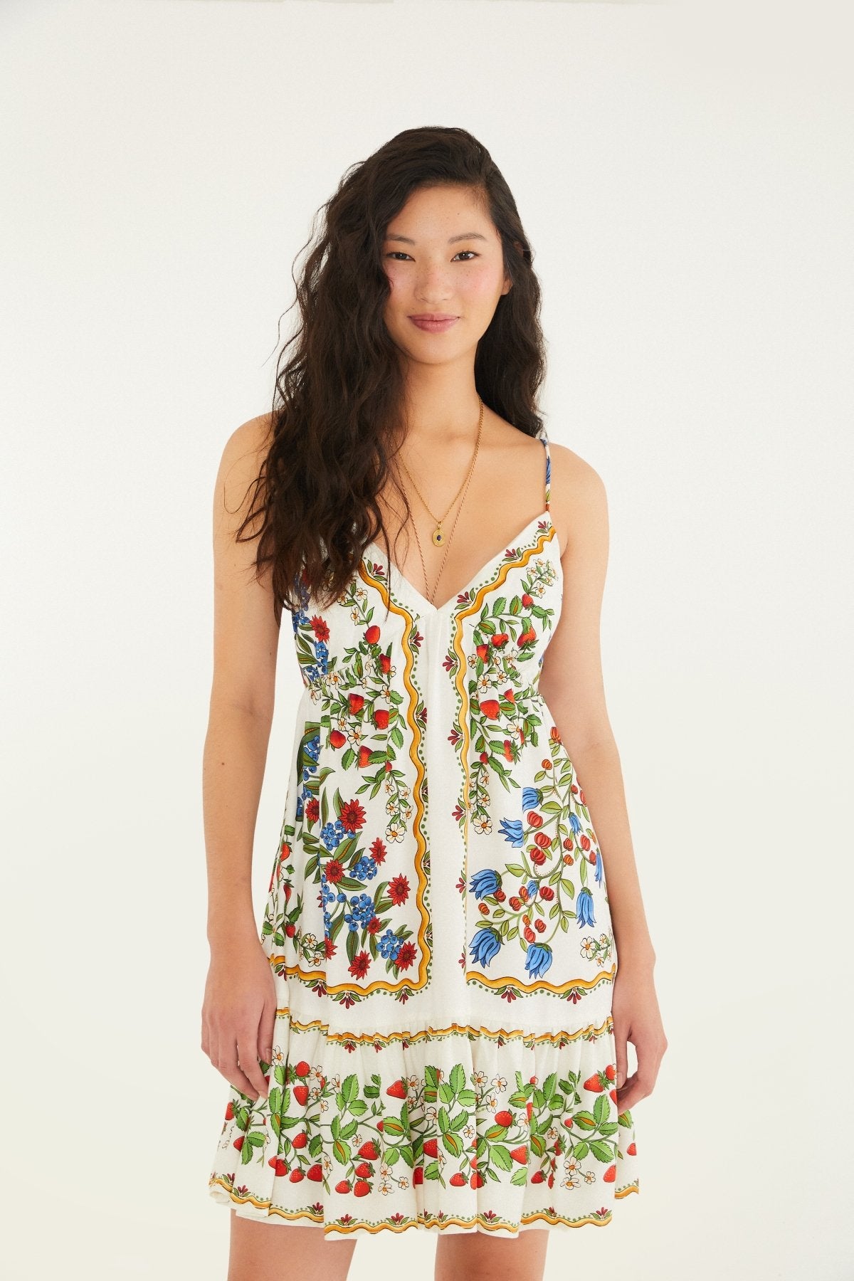 Modelo de frente usando o Vestido Curto Estampado Babado FARM, com decote em V e babado na barra.