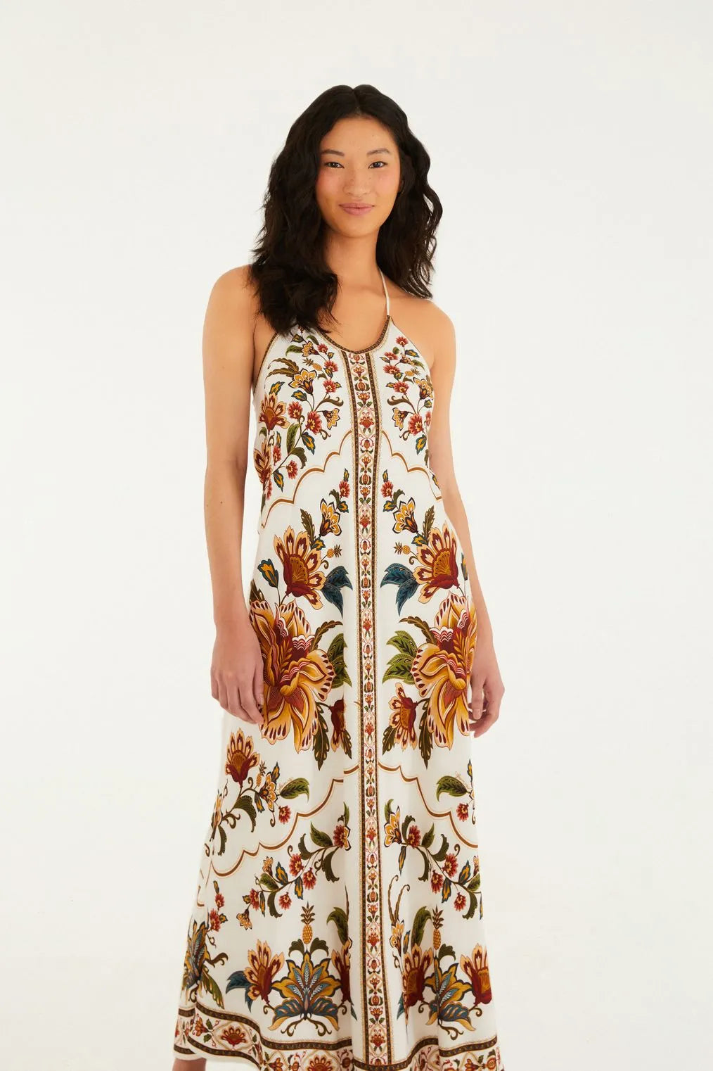 Modelo de frente usando o Vestido Estampado Jardim Majestoso FARM, com decote profundo e alças finas.